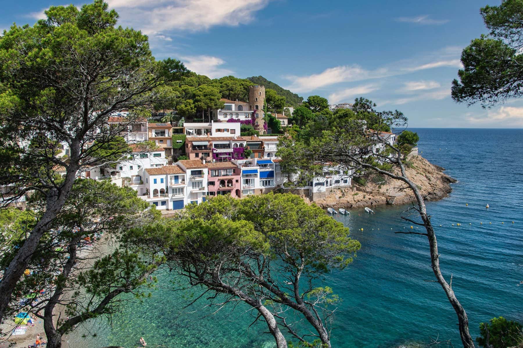 Cala de Begur con casas frente al mar entre pinos, gestión de alquiler vacacional con Winahost