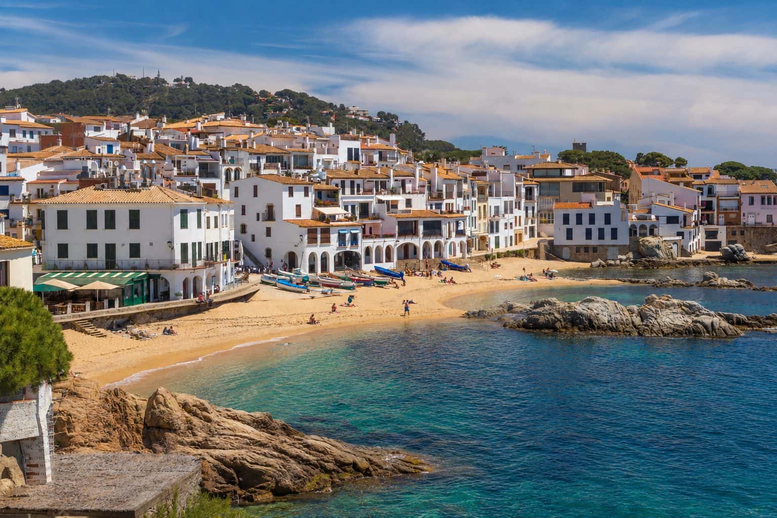 Port Bo de Calella de Palafrugell con las casas blancas de arcos y las barcas varadas, gestión de alquiler vacacional con Winahost